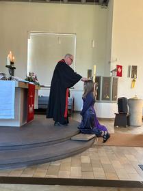 Pfarrer Jaeger segnet eine Konfirmandin